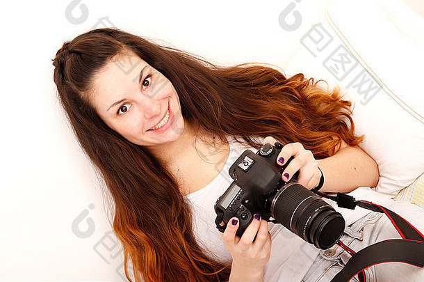 年轻的拉美裔女孩数码单反相机相机床上