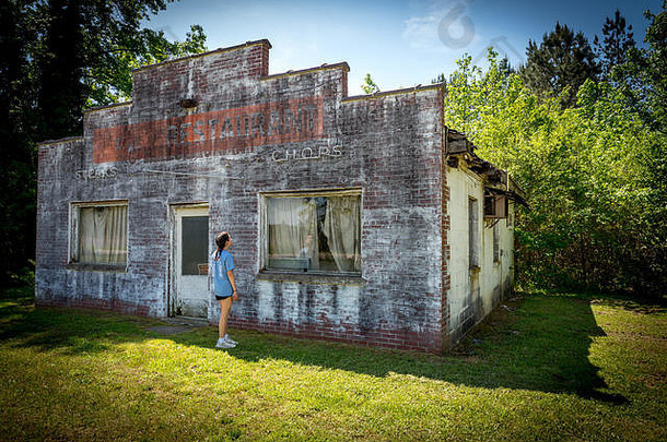 青少年女孩短裤衬衫站前面破旧的被遗弃的餐厅维吉尼亚州