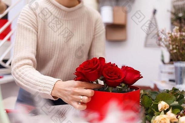 花商店花店女人使盒子红色的玫瑰过程创建hat-box花