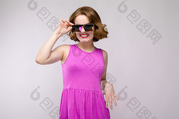 迷人的年轻的女孩粉红色的衣服灰色的背景快乐的女孩广场眼镜女孩调整眼镜