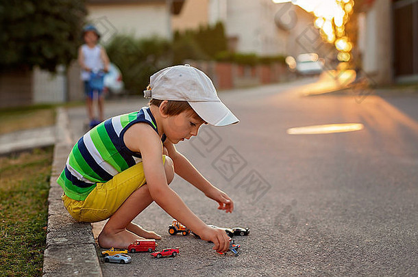 可爱的男孩玩玩具汽车街日落夏季回来基斯