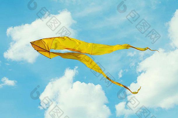 黄色的风筝飞行蓝色的天空多云的一天夏天场景自由概念
