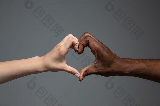 爱心手势种族宽容尊重社会团结非洲高加索人手手势灰色的工作室背景人类权利友谊和国际团结概念跨种族团结