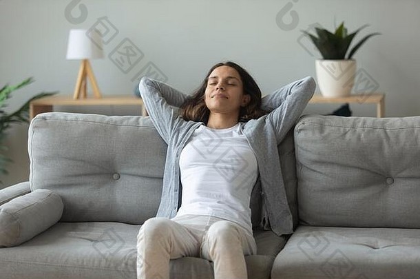 年轻的女人放松舒适的沙发呼吸新鲜的空气