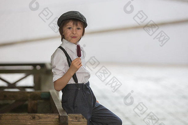 学前教育男孩可爱的孩子穿着古董风格衣服吃冰奶油城市场景
