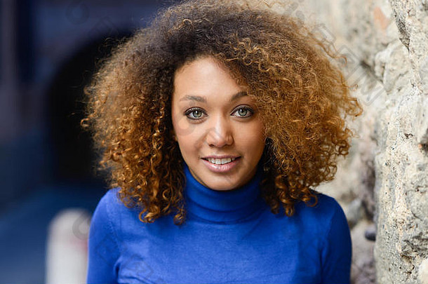 特写镜头肖像美丽的年轻的非洲美国女人非洲式发型发型绿色眼睛穿蓝色的毛衣女孩微笑