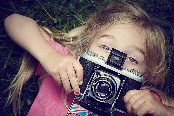 肖像女孩采取图片古董复古的电影相机说谎草背景