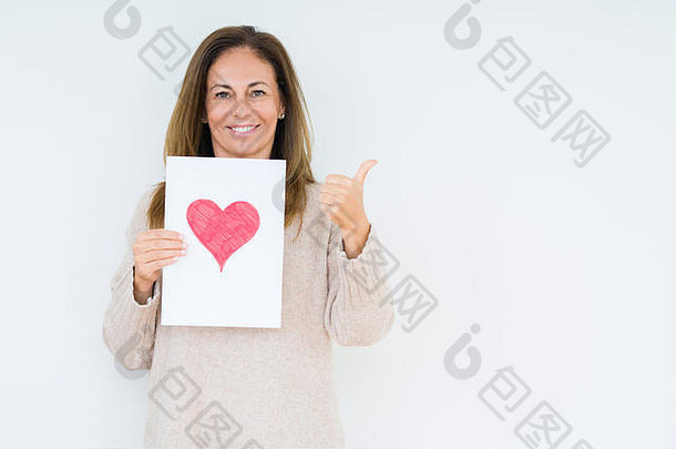 中间年龄女人持有卡礼物红色的心孤立的背景指出显示拇指一边快乐脸微笑
