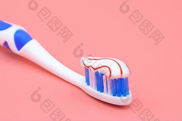 白色牙刷红色的漩涡牙膏粉红色的背景牙科医疗保健概念