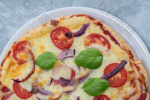 自制的披萨使面包西红柿红色的洋葱奶酪罗勒叶子白色板