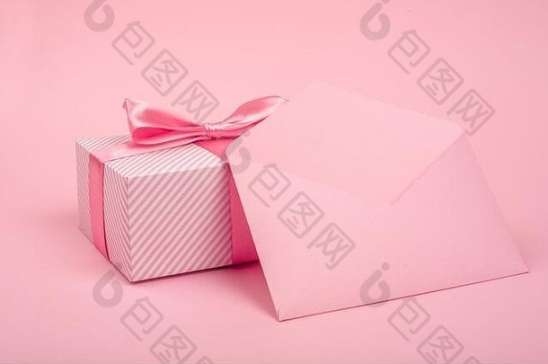 情人节一天礼物盒子包装条纹纸系丝绸丝带弓爱问候信粉红色的背景复制空间特克斯