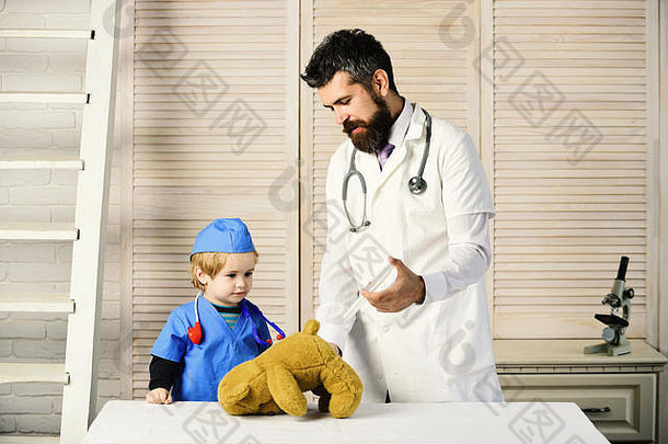 男人。胡子男孩持有注射器木背景父亲孩子感兴趣脸玩医生医疗保健童年概念兽医助理使注射泰迪熊