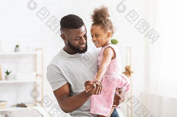 年轻的黑色的父亲持有女儿<strong>跳舞</strong>