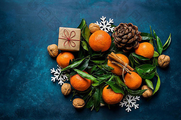 明亮的<strong>橘子</strong>绿色叶子松视锥细胞礼物盒子雪片饰品黑暗蓝色的背景圣诞节一年问候卡作文横幅