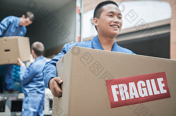 搬家公司卸货移动的携带脆弱的盒子