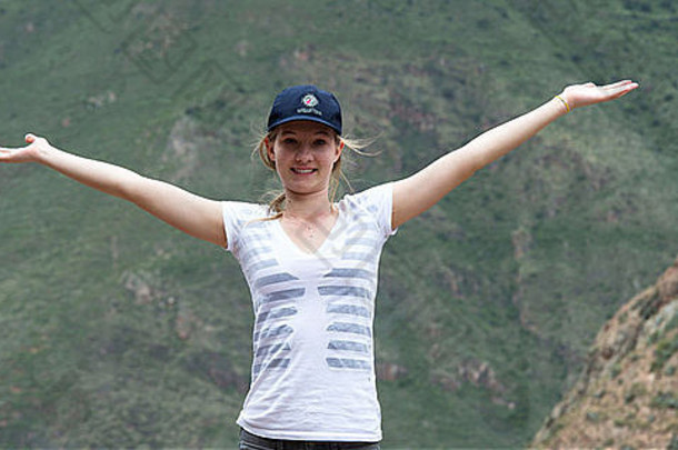 十几岁的女孩手臂伸出的神圣的谷背景库斯科地区秘鲁