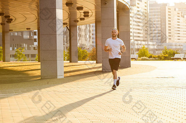 有吸引力的适合男人。运行城市日落健身锻炼体育运动生活方式概念