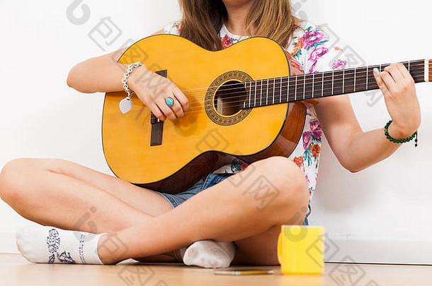年轻的女人玩声吉他唱歌