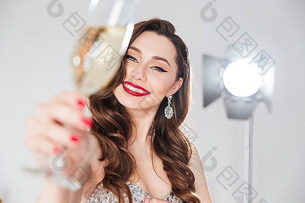 微笑迷人的女人持有玻璃香槟
