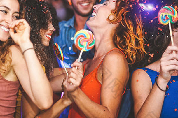 快乐朋友聚会，派对跳舞夜总会时尚的年轻的人有趣的庆祝五彩纸屑糖果棒棒糖迪斯科