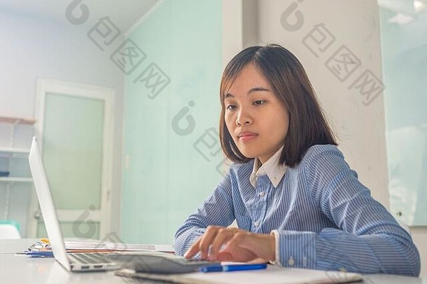 年轻的亚洲会计计算器工作电脑