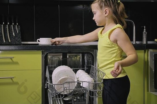 聪明的女孩学习洗碗机时尚的现代建厨房电器绿色黑色的孩子把脏菜