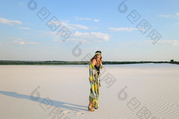 年轻的女人穿泳衣海滩袍跳舞沙子