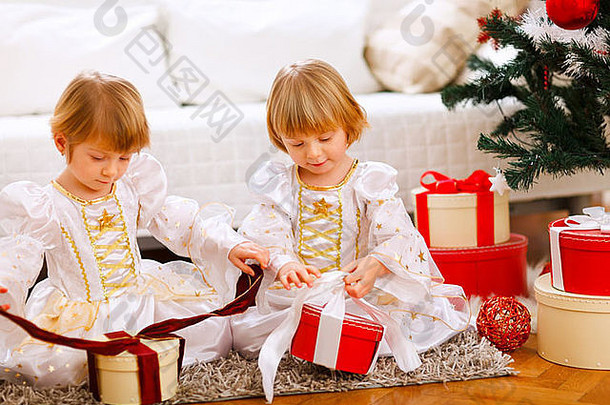 <strong>快</strong>乐双胞胎女孩开放礼物圣诞节树