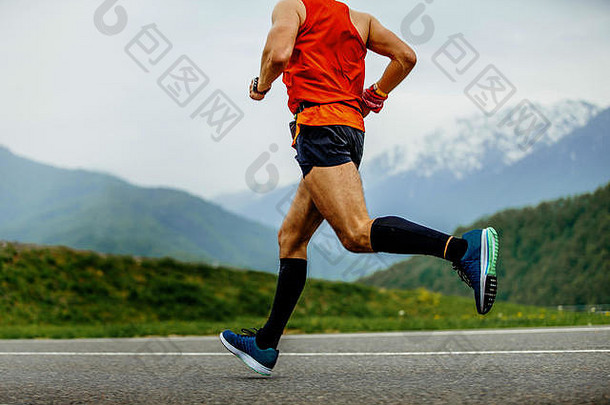 运行男人。运动员压缩袜子背景山绿色森林