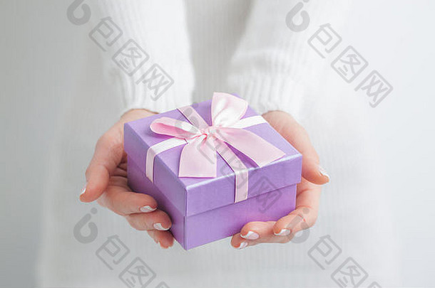 女人持有小紫色的礼物盒子手