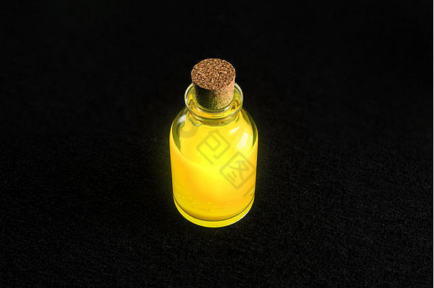 透明的瓶充满活力的金液体孤立的黑暗背景