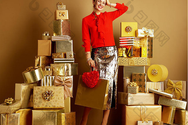 完整的长度肖像兴奋时尚的女人红色的上衣金闪亮的金片铅笔裙子购物袋红色的心桩