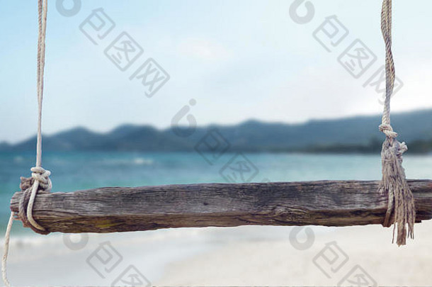 木板凳上绳子前面模糊海滩背景插图