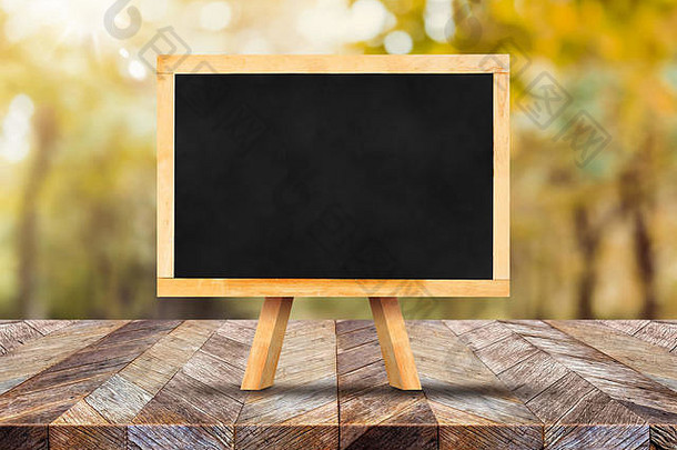 黑板上画架乡村木板材表格前模糊森林树阳光秋天秋天背景模拟显示蒙太奇