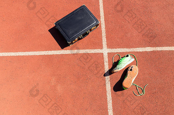 黑色的公文包一对破碎的绿色运行鞋子运行跟踪象征着竞争挑战倦怠工作业务