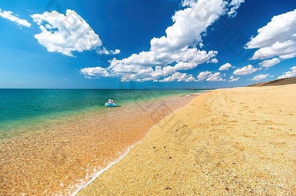 女孩他圆游泳水晶清晰的Azure海金海滩壳牌沙子概念旅行假期海