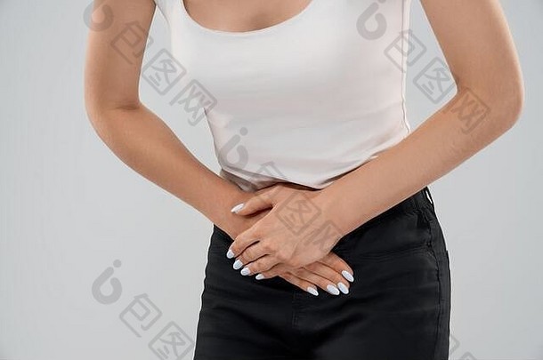 clolse弯曲隐身高加索人女人休闲西装摆姿势灰色的孤立的背景触碰较低的腹部疼痛前面作物浅黑肤色的女人痛苦疼痛胃