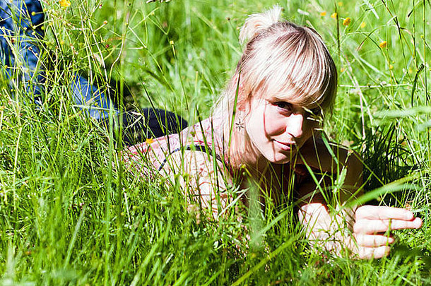 年轻的金发碧眼的女人绿色草地