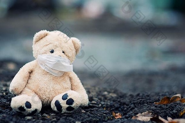 泰迪熊医疗面具坐在脏沥青复制空间