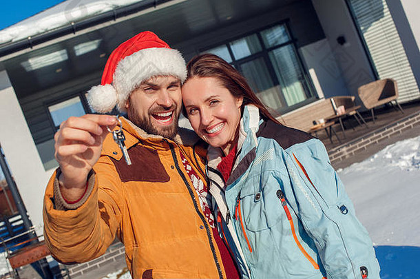 冬天假期年轻的夫妇站在户外键公寓微笑兴奋特写镜头