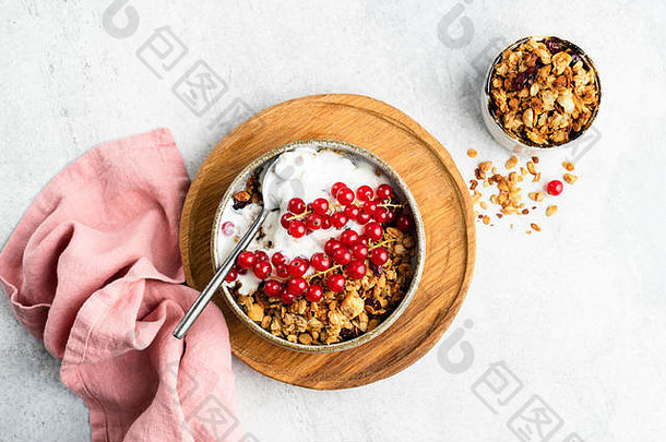 早餐麦片燕麦格兰诺拉麦片酸奶红色的醋栗浆果灰色混凝土背景表格前视图健康的早餐食物清洁吃与