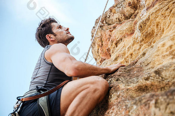 年轻的无所畏惧的男人。攀爬陡峭的墙山