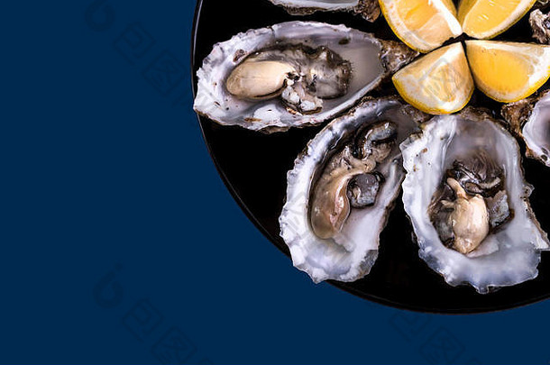 牡蛎板柠檬蓝色的背景新鲜的牡蛎特写镜头前视图健康的海食物牡蛎晚餐香槟餐厅美食食物
