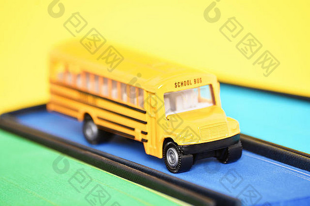 关闭拍摄玩具学校公共汽车前书蓝色的喷边缘黄色的背景