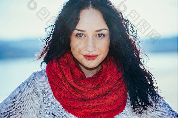可爱的年轻的女人红色的围巾河