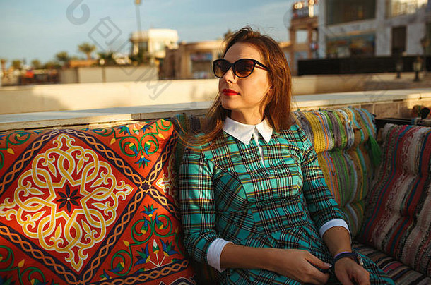 美丽的年轻的女人放松咖啡馆埃及
