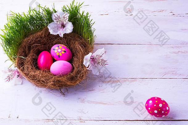 粉红色的复活节鸡蛋巢白色花绿色新鲜的草白色木背景复活节背景复活节