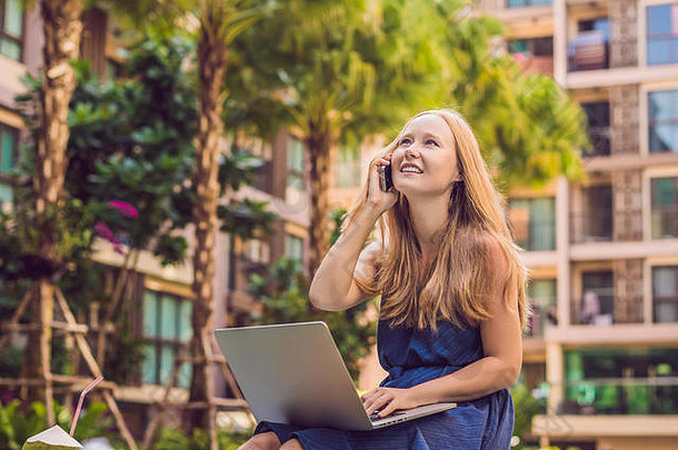 年轻的女自由职业者坐着池移动PC酒店浏览智能手机忙假期遥远的工作概念复制空间文本