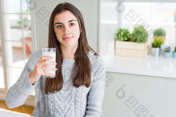 美丽的年轻的女人喝玻璃新鲜的牛奶自信表达式聪明的脸思考