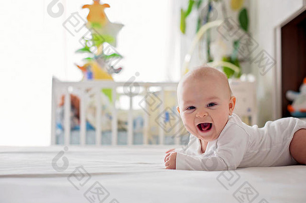 可爱的月婴儿男孩玩首页床上卧室软回来光